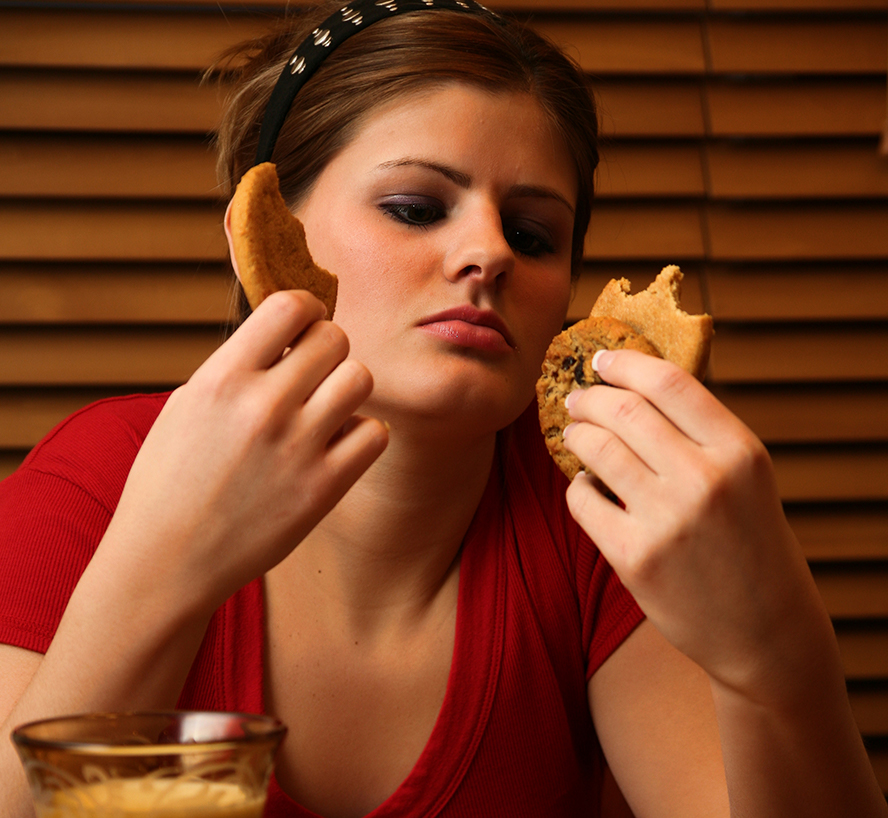 Image of a girl eating multiple cookies